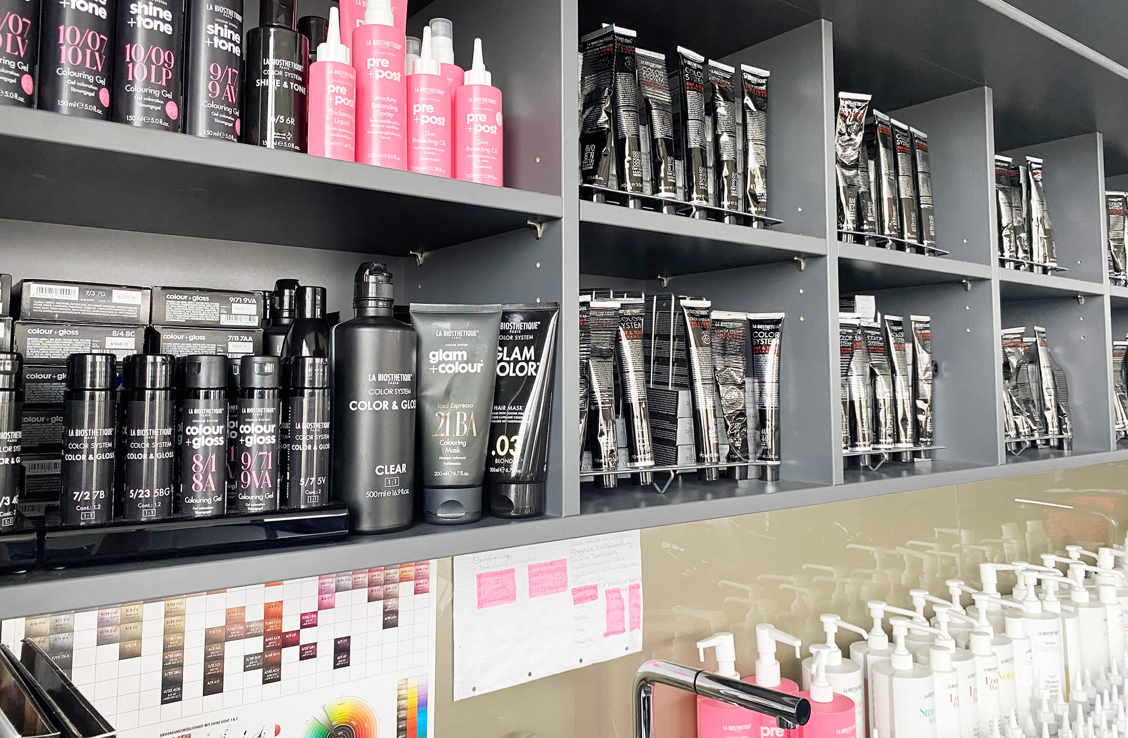 Regale Regale zeigen eine Vielzahl von Haarprodukten im Friseurraum von La Biosthétique, bereit zur Anwendung.